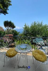 una mesa y sillas en un balcón con vistas en Poseidonia The Greek Lifestyle, en Lambírion