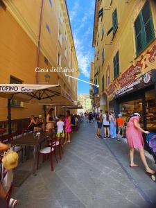 a woman in a pink dress walking down a street at Casa dell'Arco - 1 min walking from the beach in Santa Margherita Ligure