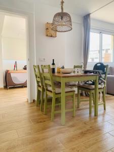 a dining room with a green table and chairs at Ocean View Luxury Las Americas in Playa de las Americas