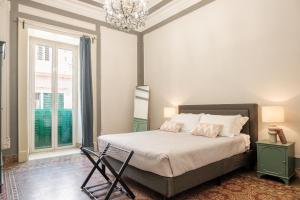 a bedroom with a bed and a chandelier at Borgo Antico Rooms in Messina