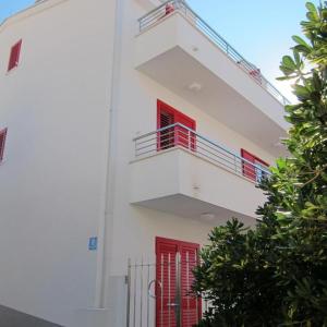 a white building with red windows and a staircase at Vila Anda in Promajna