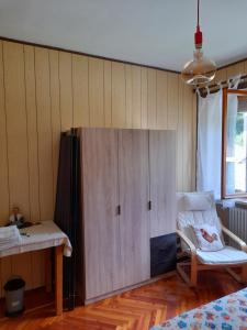 un gran armario de madera en una habitación con silla en B&B La Mëisun, en Perrero