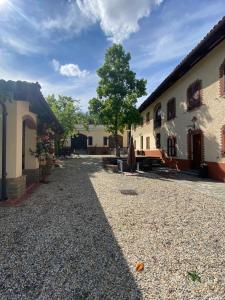 un patio de un edificio con un árbol al lado en Piemonte Country House, en Agliano Terme