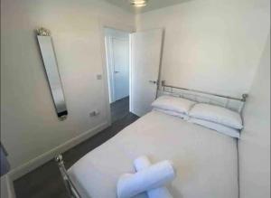 Un dormitorio con una cama blanca con toallas. en The Chalet, en Dungloe