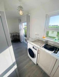 a kitchen with a sink and a washing machine at The Chalet in Dungloe