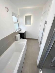 a white bathroom with a tub and a toilet at The Chalet in Dungloe