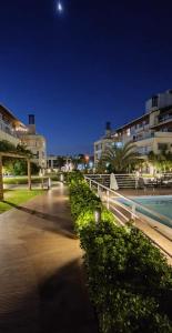 Una pasarela frente a algunos edificios por la noche en Apartamento na Praia do Campeche, en Florianópolis