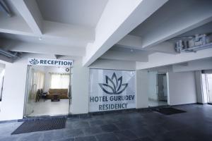 a lobby with a hotel guilbury residency sign on the wall at Hotel Gurudev Residency in Bangalore