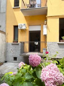 a building with a balcony with pink flowers in front of it at Ampio bilocale zona Navigli in Milan +19 photos