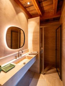 La salle de bains est pourvue d'un lavabo et d'un miroir. dans l'établissement Superbe ferme rénovée en chalet de luxe en PLEINE NATURE, à Barcelonnette