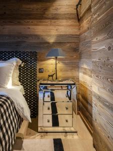 1 dormitorio con 1 cama y 1 mesa con lámpara en Superbe ferme rénovée en chalet de luxe en PLEINE NATURE, en Barcelonnette