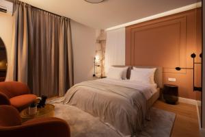 1 dormitorio con 1 cama y 1 silla en Golden Gate Luxury Rooms - Unique UNESCO Location en Split
