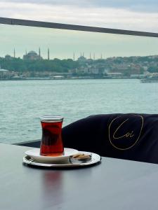a cup of tea sitting on a table next to the water at Pera Bosphorus Hotel in Istanbul