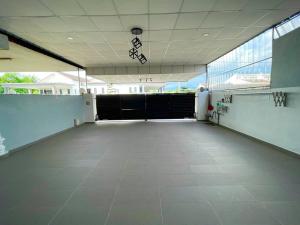 une grande pièce vide avec des portes noires dans un bâtiment dans l'établissement Cozy Stay At Raintown Taiping, à Kamunting