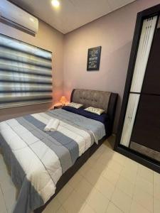 a bedroom with a large bed with a window at Cozy Stay At Raintown Taiping in Kamunting