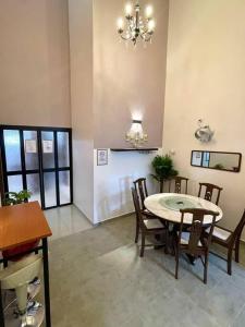 une salle à manger avec une table, des chaises et un lustre dans l'établissement Cozy Stay At Raintown Taiping, à Kamunting