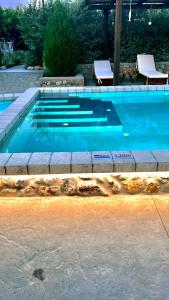 una piscina blu con due sedie di Aithonas Villa a Archangelos