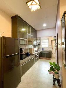 a large kitchen with stainless steel appliances at Cozy Stay At Raintown Taiping in Kamunting