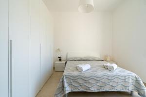 um quarto branco com uma cama com toalhas em Dimora le Dune a 100 MT dal mare em Campomarino