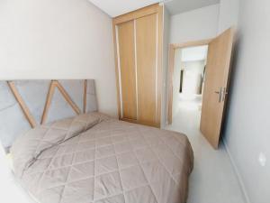 - une chambre avec un lit et une porte en bois dans l'établissement Appartement cosy proche Aéroport, à Deroua