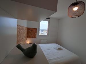 a room with a bed and a black chair at Appartement Terrasse Sud Dernier étage + Parking in Le Havre