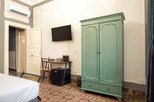 um armário verde num quarto com uma cama em Borgo Antico Rooms em Messina