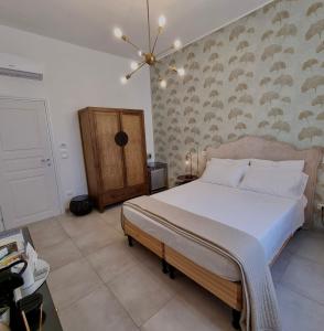 a bedroom with a large bed and a chandelier at Dimora Giusti in Lecce