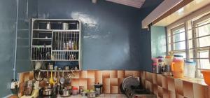 a kitchen with a counter and a blue wall at Heath Cote in Ooty