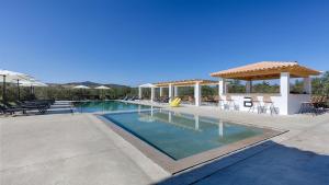 a swimming pool with a gazebo and tables and chairs at Brisot in Galatas