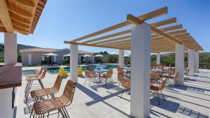 a patio with tables and chairs next to a pool at Brisot in Galatas +106 photos