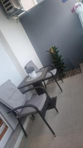 un patio con 2 sillas, una mesa y una planta en Apartment Lara en Podstrana