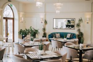 Hotel Toscania في Włoszakowice: مطعم بطاولات وكراسي وأريكة