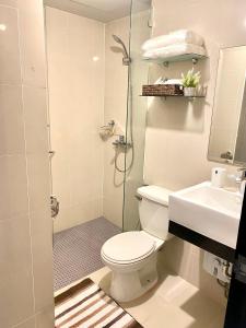 ein Bad mit einer Dusche, einem WC und einem Waschbecken in der Unterkunft Frost at Manhattan Heights TowerB in Manila