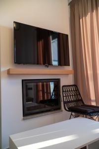 a living room with a fireplace and a flat screen tv on the wall at suite apartment Αdonis in Agiokampos