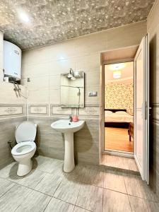 a bathroom with a toilet and a sink at Guesthouse Mtkvari in Nak'alak'evi