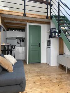 a living room with a green door and a kitchen at La Carretariá - Intra•muros - Wifi in Avignon