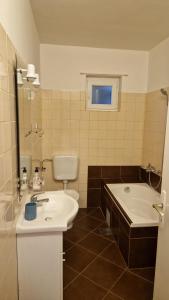 een badkamer met een wastafel, een bad en een toilet bij Apartments Miro Omišalj in Omišalj