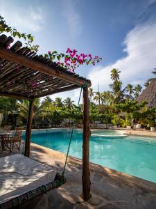 a swinging bed next to a swimming pool at Tropical Boutique Hotel & Resto in Pingwe