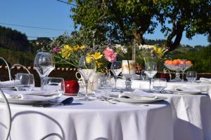 - une table blanche avec des verres, des assiettes et des fleurs dans l'établissement Le Domaine de la Source, à Chauffailles