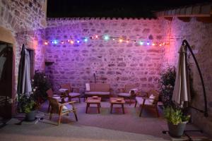 d'une terrasse avec un mur en briques et des lumières violettes. dans l'établissement Le Domaine de la Source, à Chauffailles