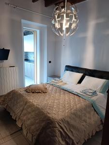 1 dormitorio con 1 cama grande y lámpara de araña en Prestine', en Nesso