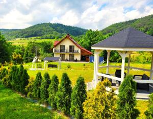 a house in a field with a gazebo at Willa Beskidzka in Myślenice