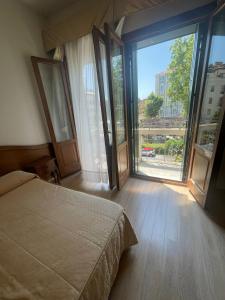 sypialnia z łóżkiem i dużym oknem w obiekcie Hotel Cristallo w Lido di Venezia