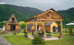 une cabane en rondins avec une terrasse et un pavillon dans l'établissement Eco House Borjomi, à Bordjomi