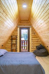 een slaapkamer met een bed in een houten hut bij Eco House Borjomi in Borjomi