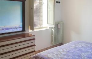 Montorio al VomanoにあるAmazing Home In Montorio Al Vomano With Kitchenのベッドルーム(ドレッサー、テレビ、窓付)