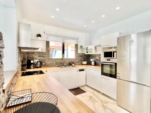 a kitchen with white cabinets and a wooden floor at Villa Cielo with private pool in Canal D'Amour by DadoVillas in Sidari