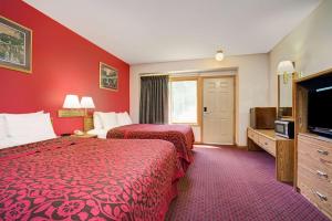 a hotel room with two beds and a flat screen tv at Travelodge by Wyndham Red Wing in Red Wing