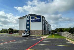 a large building with a car parked in a parking lot at Microtel Inn & Suites by Wyndham Bossier City in Bossier City