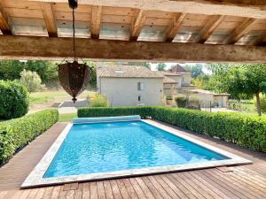 uma piscina num quintal com um deque de madeira em Les géodes du Domaine Jean Got, proche de Saint Emilion em Lugaignac